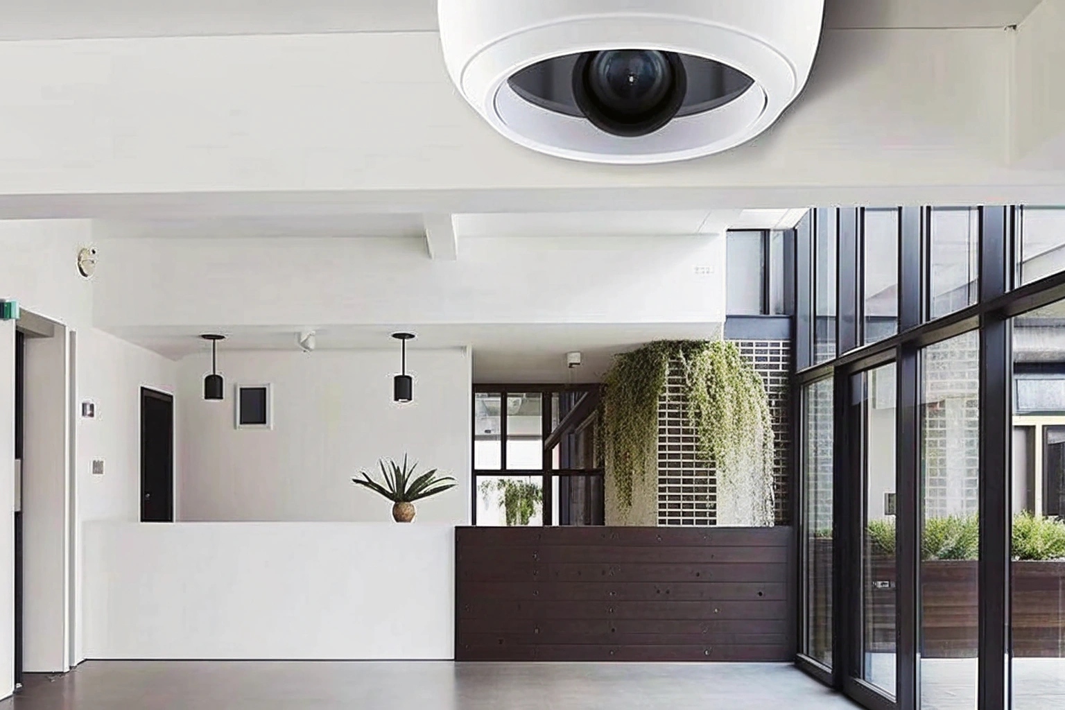 A sleek, modern office lobby with a discreet mini camera mounted on the ceiling corner