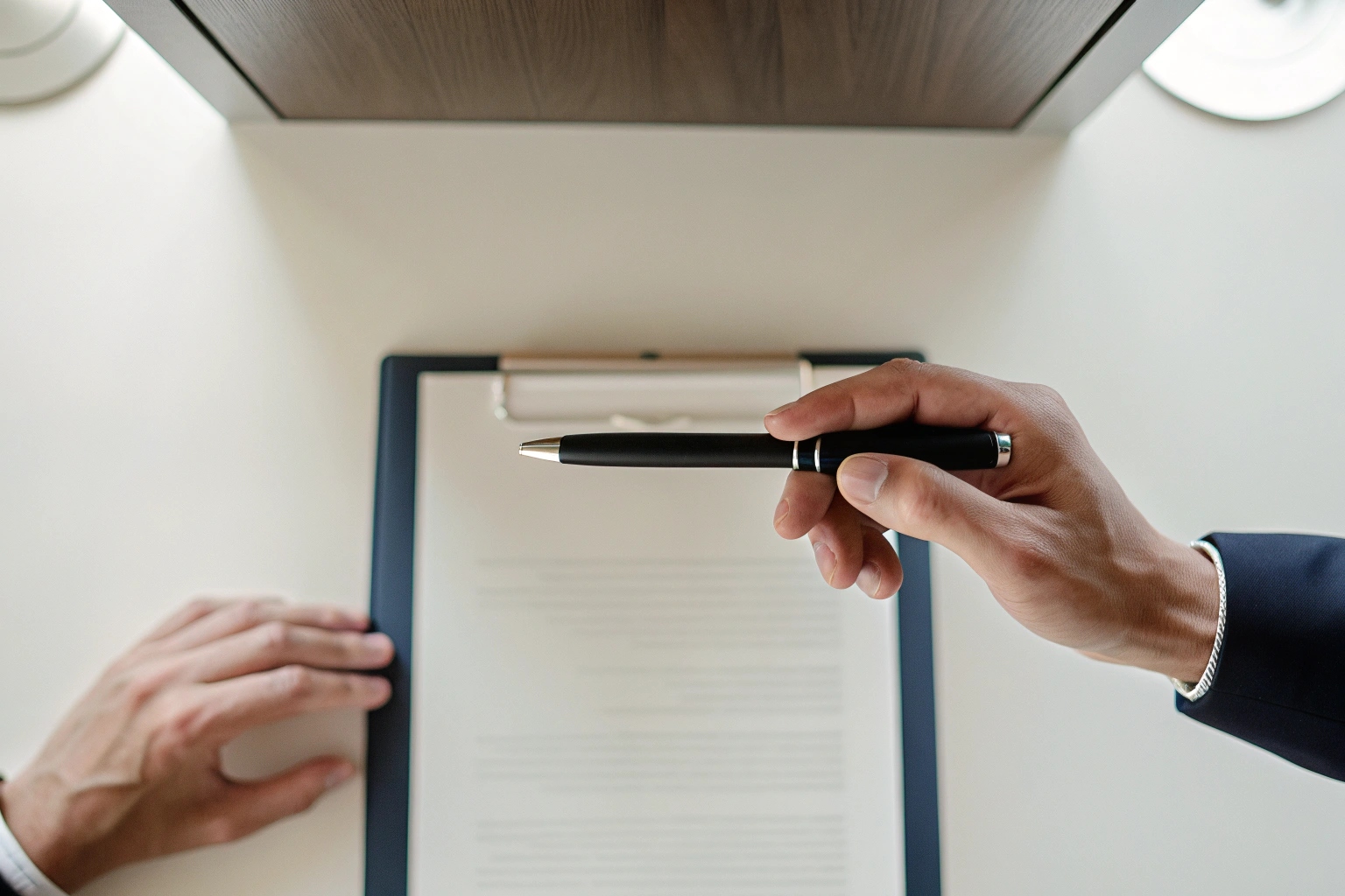 A close up of a hand holding a spy pen camera signing a document