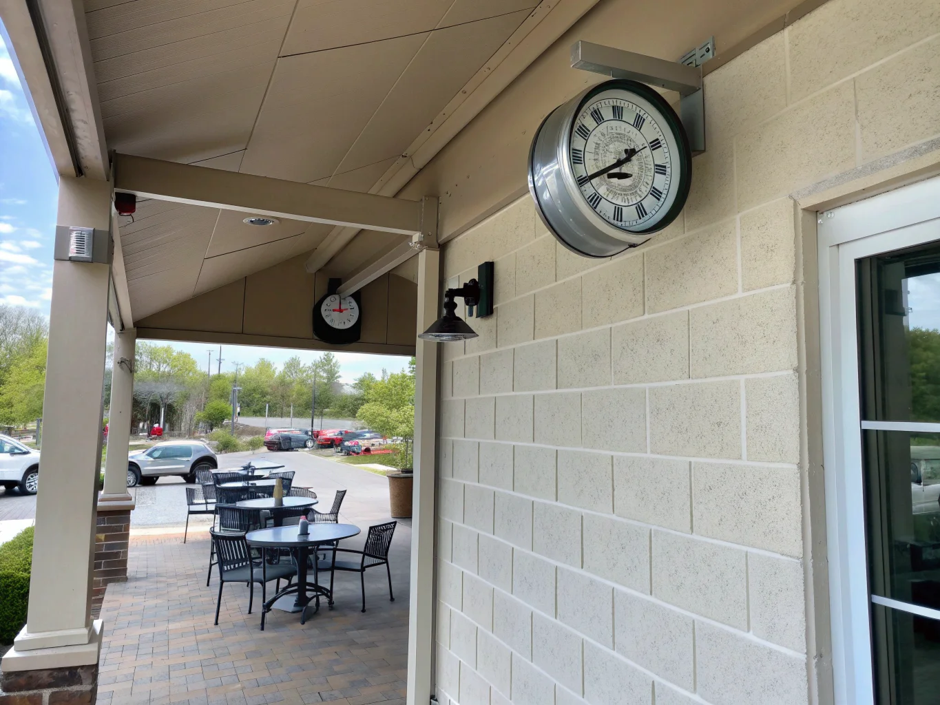 Una telecamera spia nascosta in un orologio da parete posizionato sotto un portico coperto, al riparo dalle intemperie