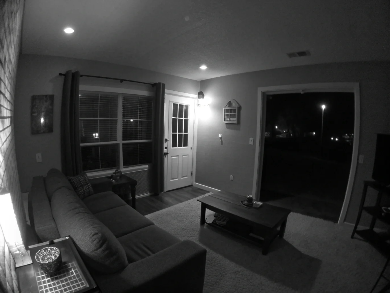 A hidden camera's clear black-and-white night vision view of a darkened living room