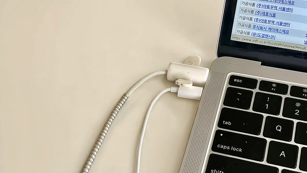 Close-up of a laptop keyboard and connected cables on a desk